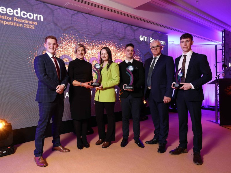 The winners of the Seedcorn competition stand in a line holding their awards.