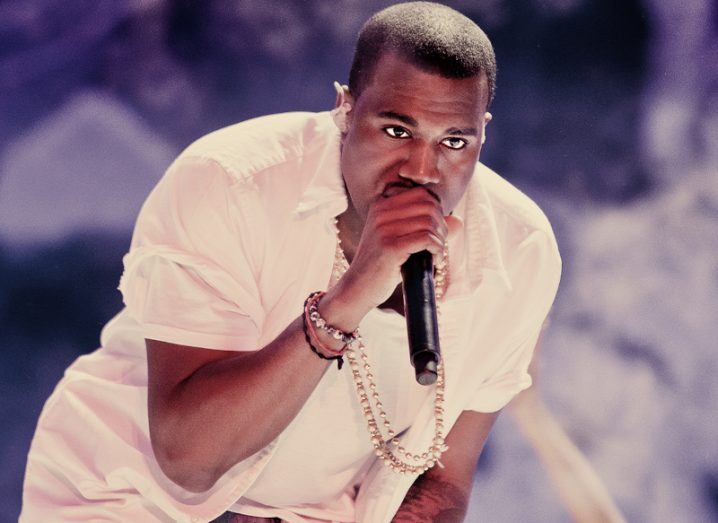 US rapper Kanye West, also known as Ye, holding a microphone and performing on a stage.