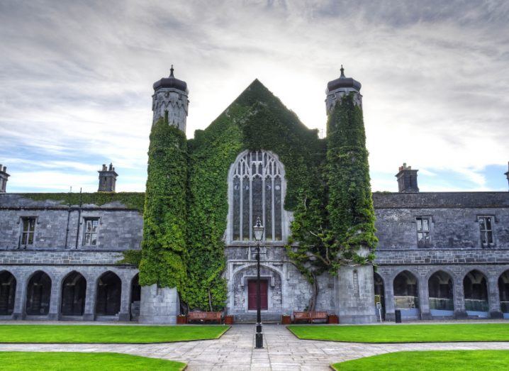 The Quadrangle building at University of Galway, a grey stone building with grass around it.