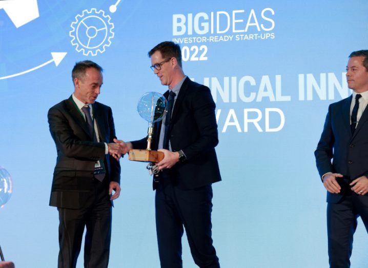 A man presenting another man with an award at the clinical innovation awards.