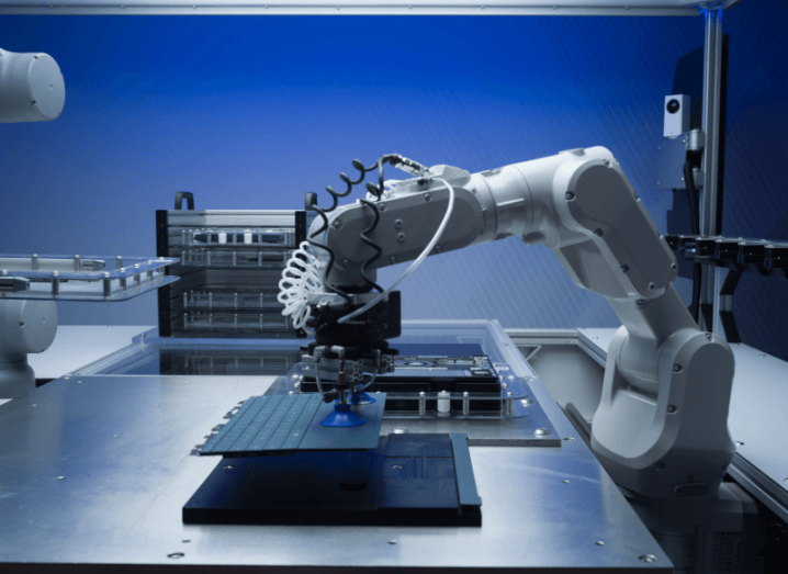A robotic arm holding the keyboard of a PC above a metallic table. An image from Dell's 'Microfactory' where Concept Luna is being developed.