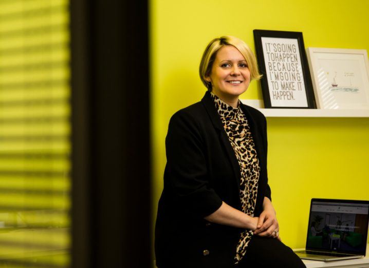 Sinead Doherty of Fenero sits on a desk in a bright office.
