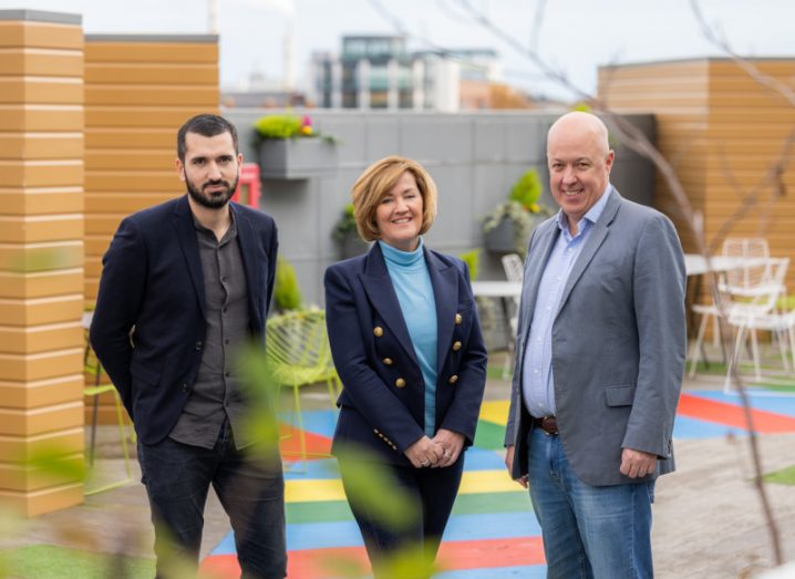 Two men and a woman stand next to each other in an outdoor space at the Google office in Dublin.