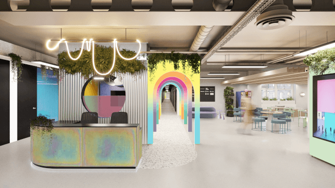 Photo of the interiors of a Huckletree co-working space with desks, chairs, a reception and lots of lights and plants.