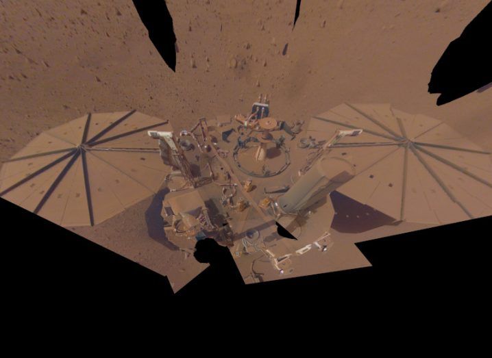 A selfie taken by the InSight Mars lander. The spacecraft is sitting on the red planet, and dust can be seen covering its solar panels.