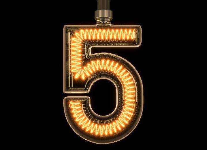 The number five, lit up with yellow wiring, on a dark background.
