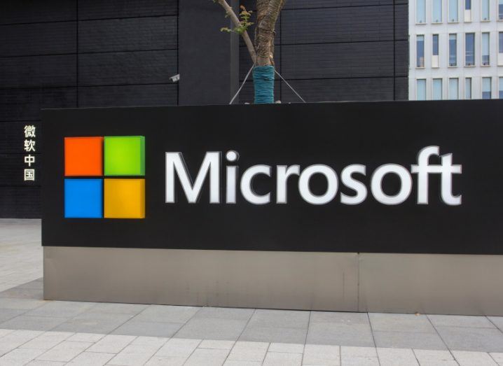 Microsoft logo on a black entrance sign, with a building behind it.