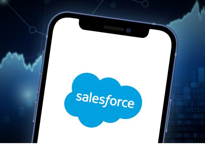 A phone with the Salesforce logo on it superimposed on a stock exchange graphic.
