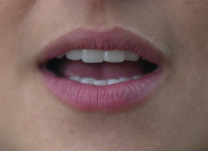 Close-up of a person's mouth as they speak.