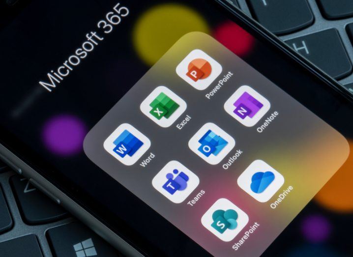 A close-up of a phone showing multiple Microsoft 365 applications.