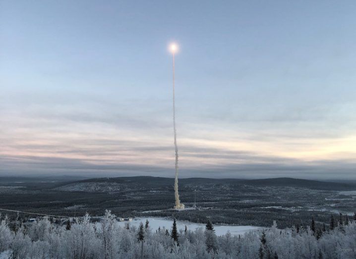 A rocket being launched from Spaceport Esrange in northern Sweden. Icy trees surround the site.