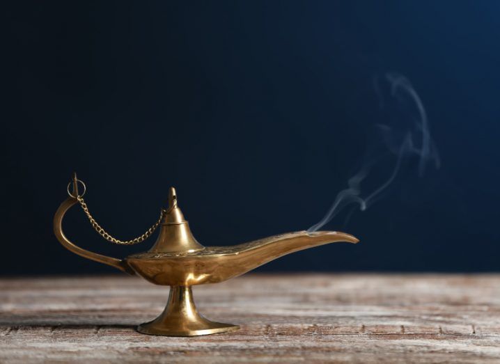 A genie lamp on a wooden table, with a small plume of smoke rising from the nozzle.