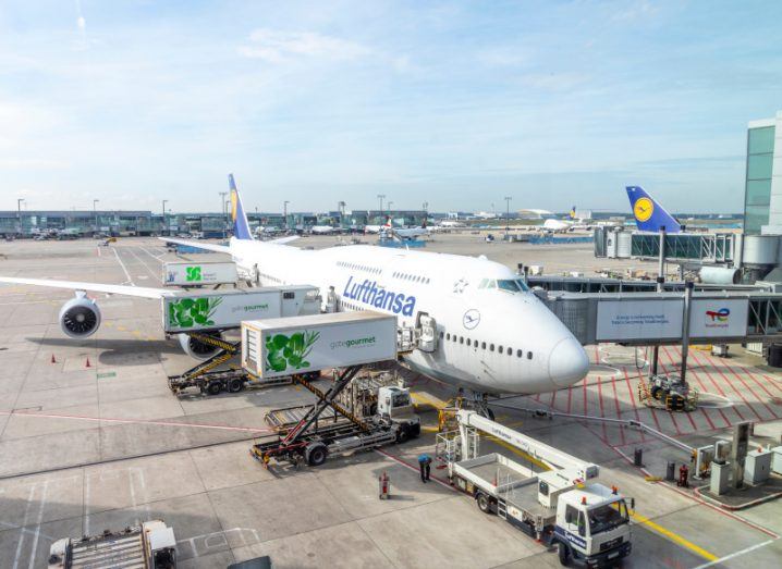 A plane with the Lufthansa logo on the side, docked at an airport.