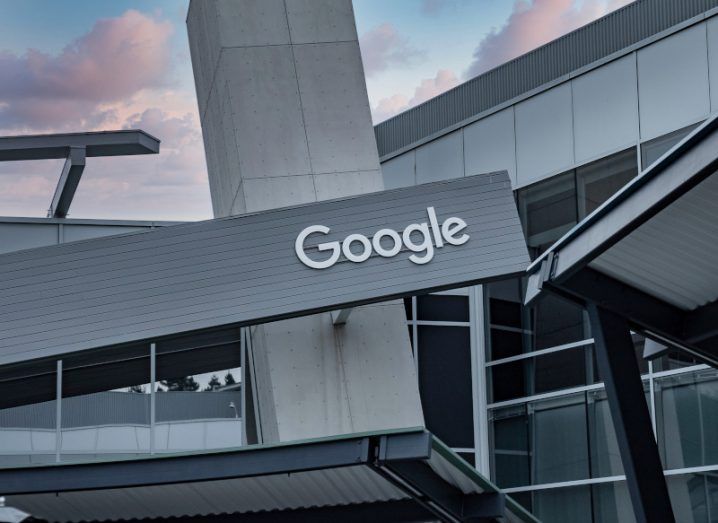 The outside of a Google office in front of a sunset sky.