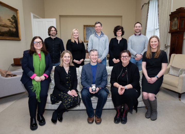 Ten people are in an ornate room, half of them are sitting on a couch in the foreground. They are a research team from University of Limerick that recently won an award.