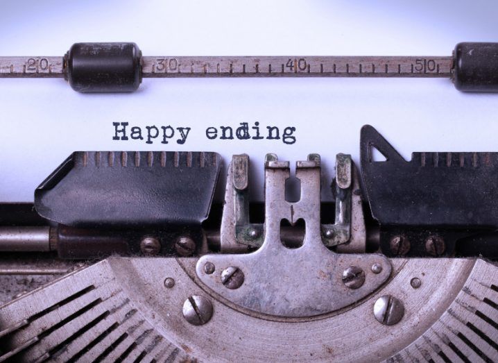 A close-up of a typewriter with a white piece of paper and the words Happy ending typed out.