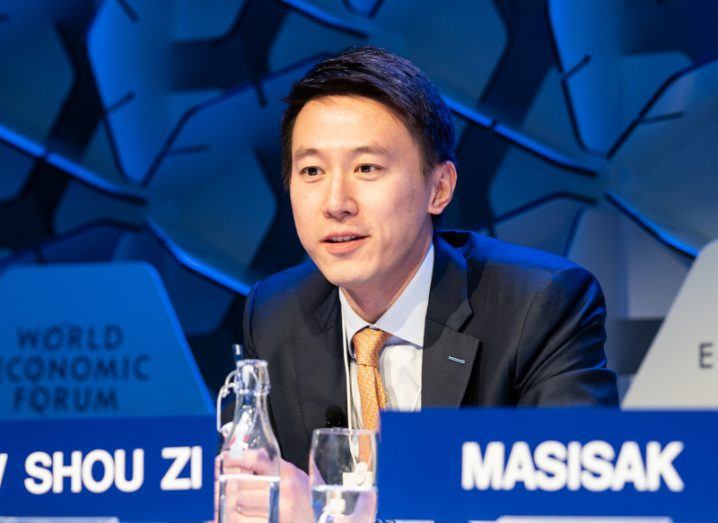 TikTok CEO Shou Zi Chew, wearing a suit and sitting at a table.