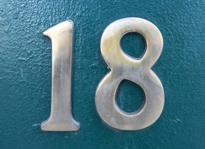 The number 18 in silver lettering on a blue background.