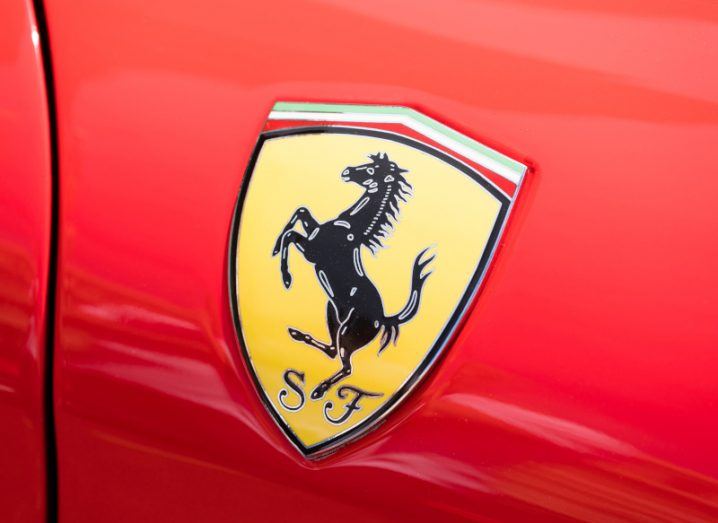 The Ferrari logo on the side of a red vehicle.