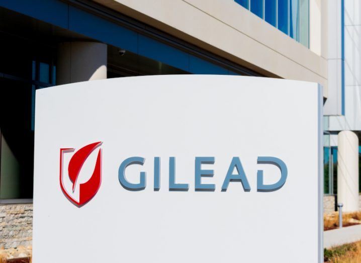 The Gilead Sciences logo on a white sign in front of a building.