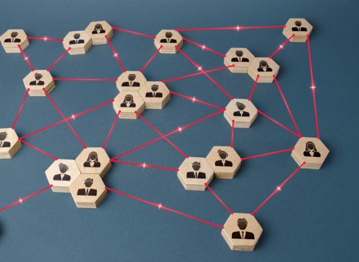Multiple wooden circles with people icons on them, connected to each other with red lines. Used to represent decentralisation.