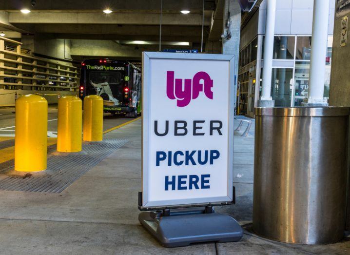 A sign with the Lyft and Uber logos, designating a pickup location for drivers.