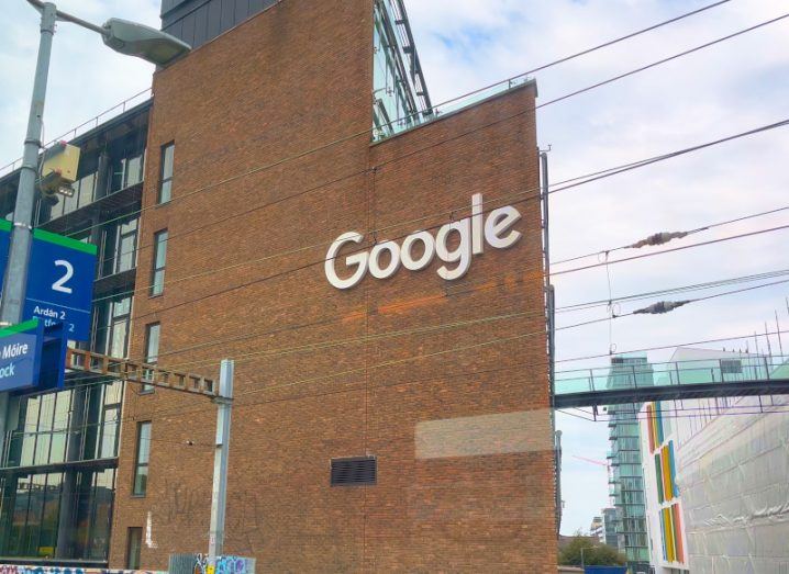 The Google logo on the side of a brown building in Dublin, with a grey sky in the background.