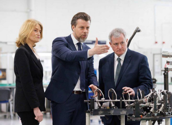 Three people looking at engine parts at Lufthansa Technik Shannon.