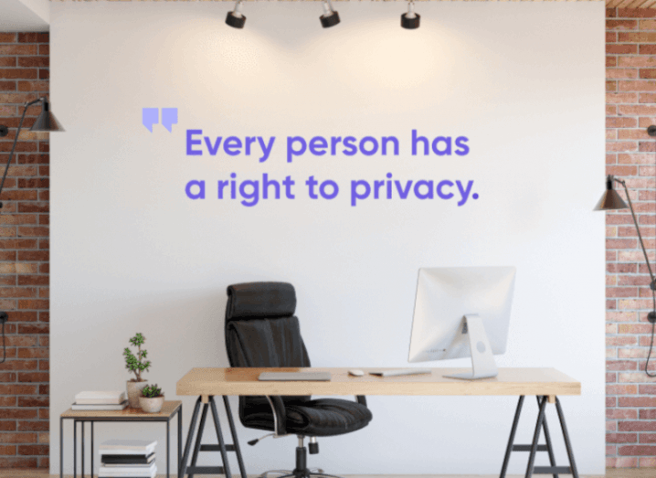 An office table and chair in front of a white wall with the phrase "Every person has a right to privacy" written on it.