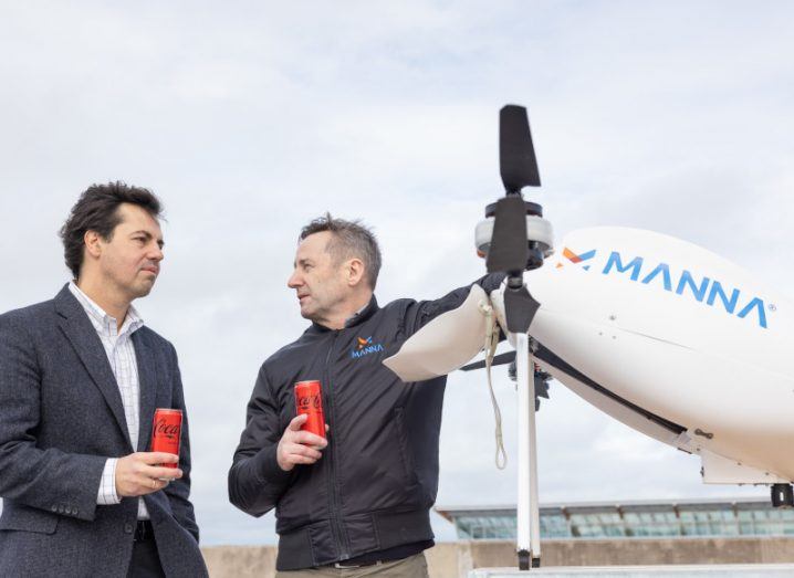 Two men looking at each other as one holds onto a Manna drone.