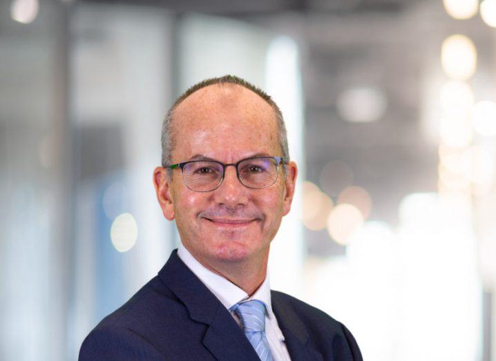 Headshot of ISB Global CEO Chris Williams, wearing a suit with a blurred office background.