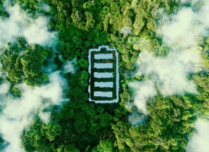 Image of a battery-shaped pond in a forest captured from a bird's eye view to symbolise sustainable energy.