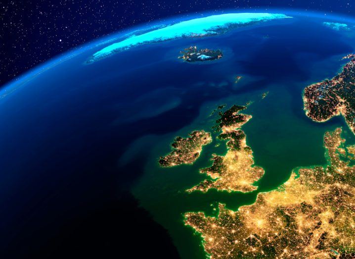 A view of the Earth from orbit, showing Ireland and other countries at night with stars visible in the distance.