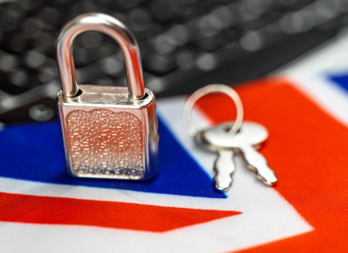 UK online safety concept image showing a silver padlock and key on a Union Jack flag with a computer.