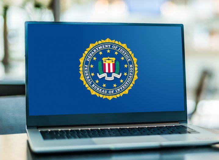 A laptop on a wooden table with the FBI logo on the screen.