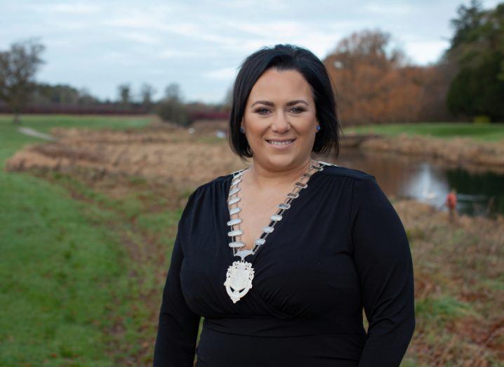 A woman stands in a field smiling at the camera. She is Emma Early Murphy, the 2023 president of Network Ireland.