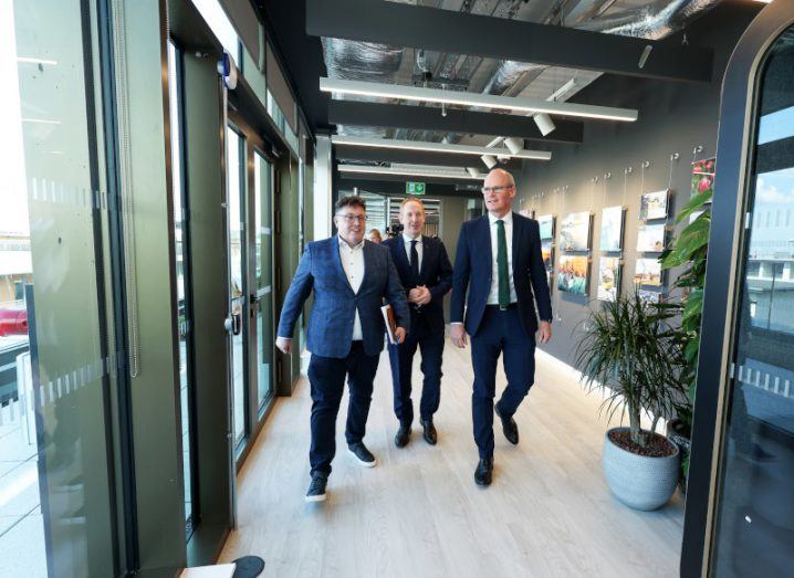 Three men in suits walk down a corridor in the new Workday office in Dublin.