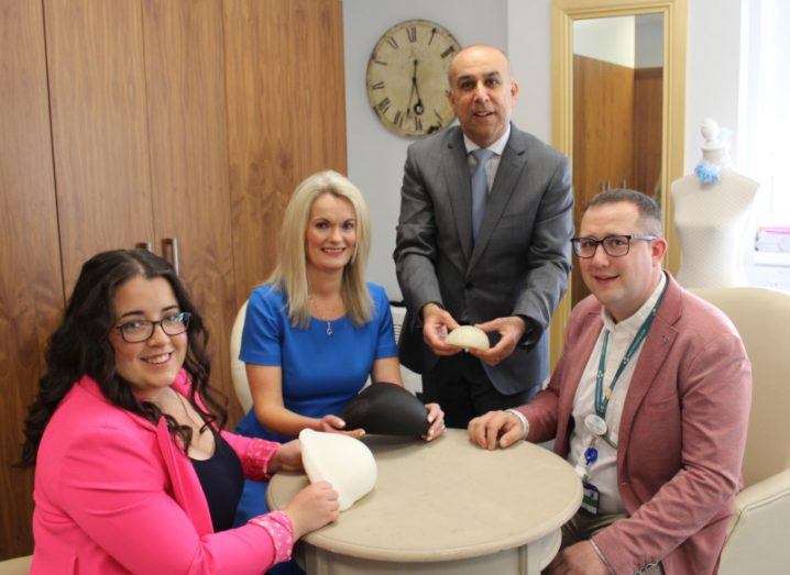 Four people from University of Limerick in a room holding 3D printed breast prostheses.