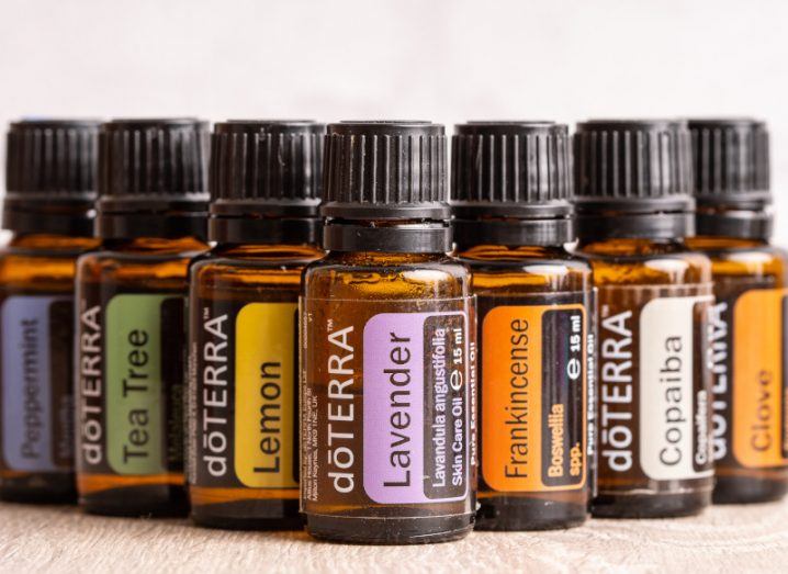 A batch of dōTerra essential oil bottles with different label types on each bottle, with a pale background.