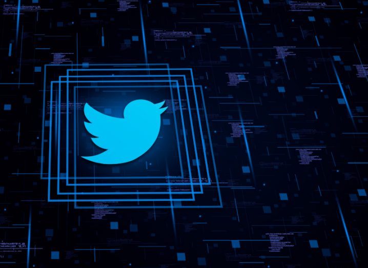 The Twitter logo in a dark background with blue digital squares surrounding the logo.