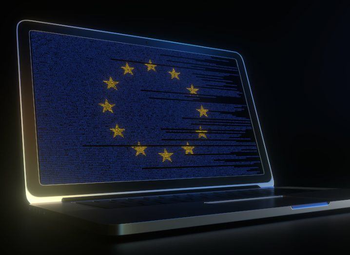 A laptop with the EU flag and blue computer code on the screen.