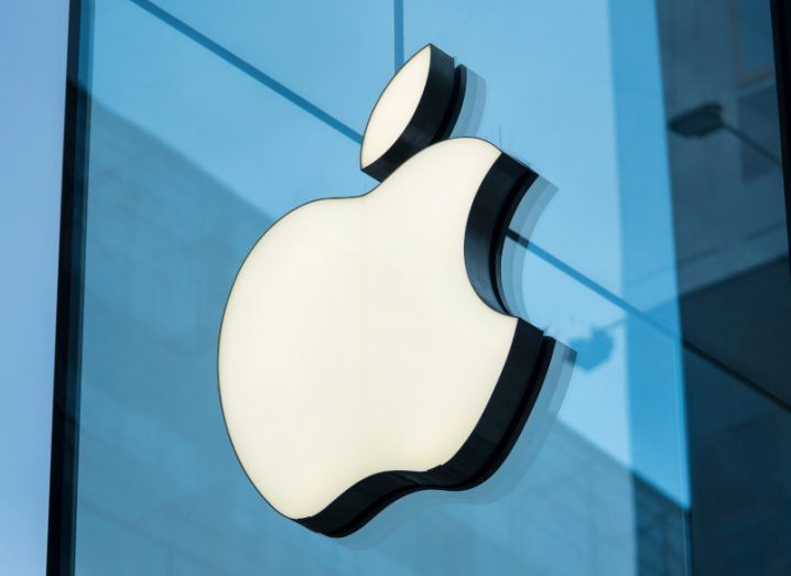 A close up of the Apple logo on a glass building.