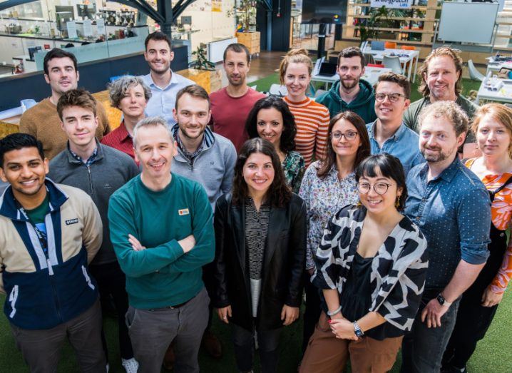 A group of men and women standing together, with the inside of the Dogpatch Labs office behind them.