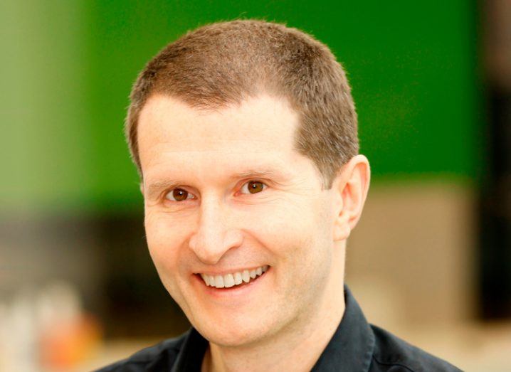 A headshot of a man smiling with a blurred background behind him. He is Nick Power, CTO of Cubic Telecom.