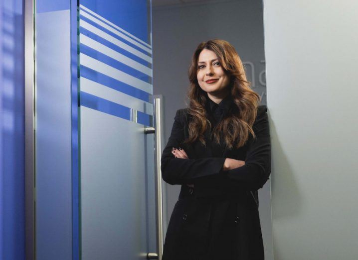 A woman standing with her arms crossed in an office doorway. She is Raluca Saceanu, CEO of Smarttech247.