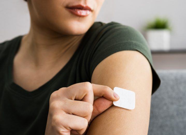 Woman applying a white patch on her arm. Symbolises the fentanyl patches being developed by Nutriband.