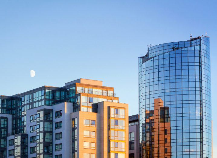 Modern buildings in Ireland adorn the skyline with the moon visible in the background.