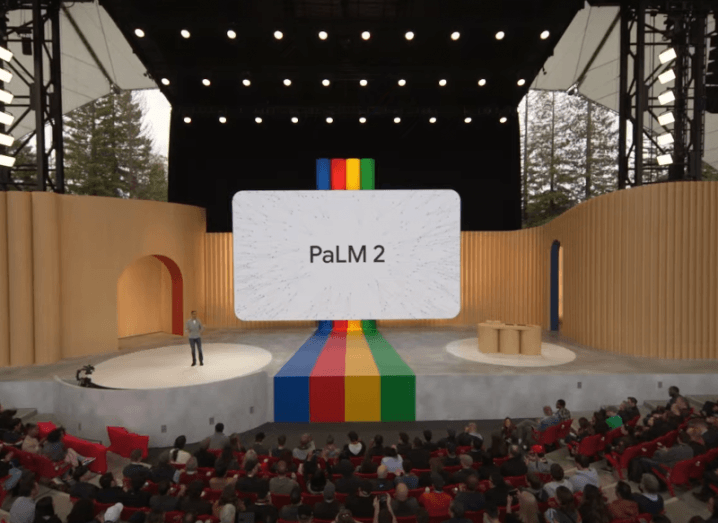 A man on a stage with a crowd watching and a white screen that says PaLM 2. An image from the Google I/O event in 2023.