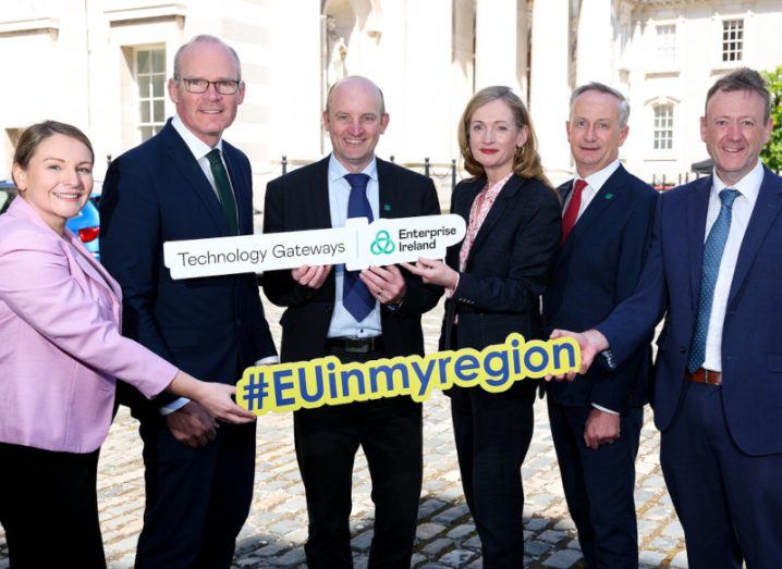 Four men and two women standing together holding a Technological Gateway Enterprise Ireland sign and another sign that says EU in my region.