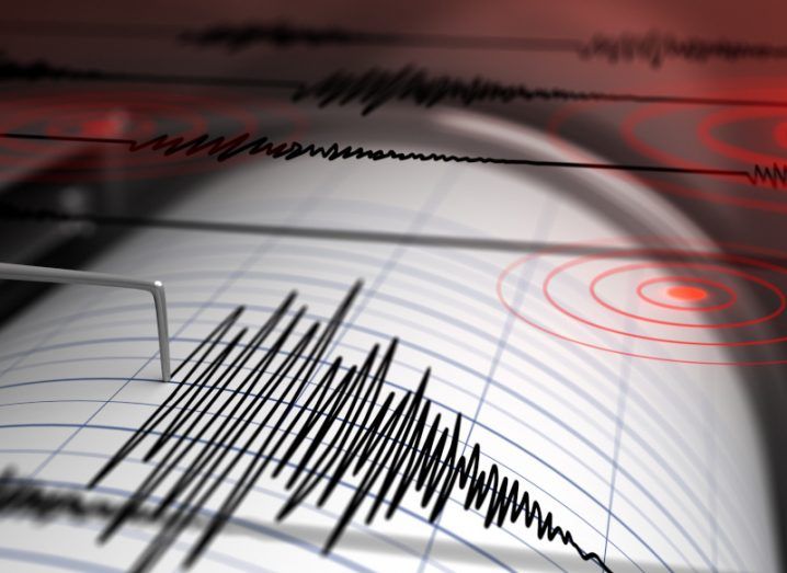 Seismograph measuring earthquakes with graph paper and a needle drawing a jagged line. There are red target images superimposed on the paper.